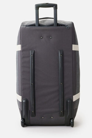 The Rip Curl Jupiter 80L Classic Surf Travel Bag stands upright on a light background, showcasing its large, rectangular gray design with black handles and wheels. It features two black horizontal strips and vertical reinforcements on the back, along with an extended pull handle at the top. This bag is lightweight yet sturdy, perfect for any adventure.