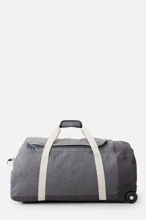 The Rip Curl Jupiter 80L Classic Surf Travel Bag is a large, stylish, gray rolling duffel with white handles and a retractable black handle. It's perfect for surf travel with its lightweight design, featuring a zippered compartment and wheels on one end for easy transport. Set against a plain white background, this eco-friendly bag combines practicality with elegance.