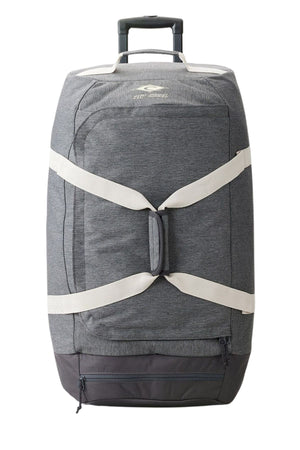 Introducing the Rip Curl Jupiter 80L Classic Surf Travel Bag, a gray travel bag with wheels, equipped with a handle and accented by white straps. This lightweight duffel offers a convenient zippered pocket at the bottom and proudly displays an eco-friendly logo on the top front.