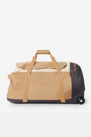 The Rip Curl Jupiter 80L Travel Bag, a large beige rolling duffle made of water-resistant ripstop with tan straps and a dark gray base, is shown sideways against a white background. It features a top zipper, small external pocket, and a single recycled polyester wheel.