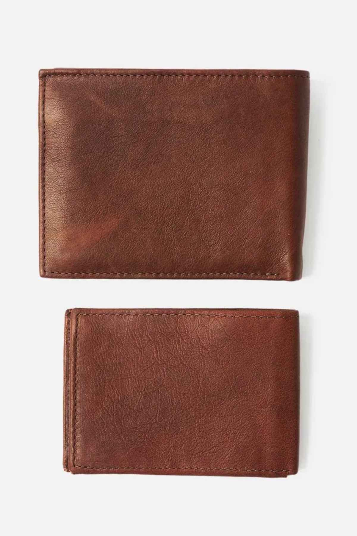 Two Rip Curl K-Roo RFID 2 in 1 Wallets, crafted from premium kangaroo leather, are displayed on a plain white background. Featuring sleek and slim designs, the larger wallet is positioned above the smaller one. Both wallets showcase visible stitching and offer RFID protection for added security, combining premium durability with style.