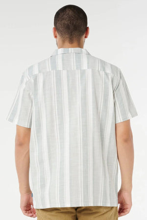 A person with short hair is shown from the back, wearing a Rip Curl Mod Cali Stripe Short Sleeve Shirt in light gray and white stripes, paired with light brown pants, standing against a plain white background.