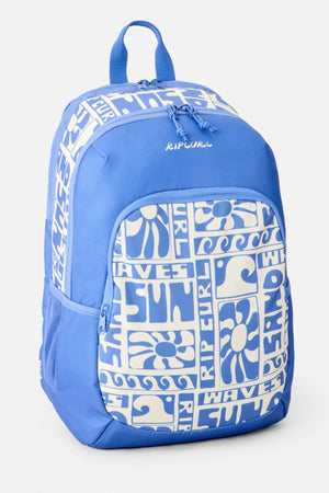 The Rip Curl Ozone 2.0 30L Backpack in blue features a white front pocket with bold graphic prints of waves, flowers, and the words "Rip Curl," "Sun," and "Wave" arranged in a tiled pattern.