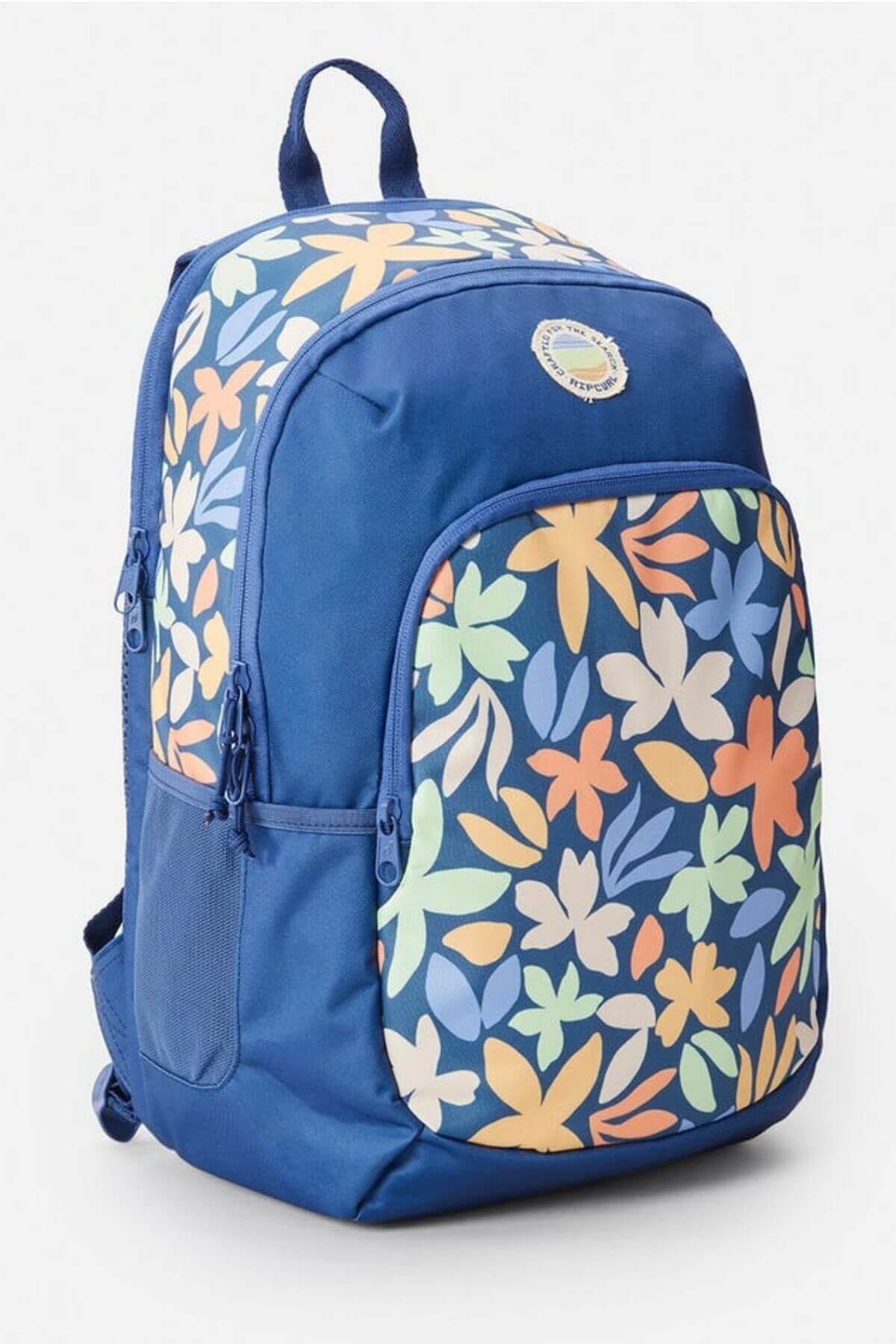 The Rip Curl Ozone 2.0 30L Backpack is a stylish blue bag with a front pocket featuring vibrant orange, yellow, light blue, and green floral patterns. It has multiple zippered compartments, a top handle, and is computer compatible for daily use.