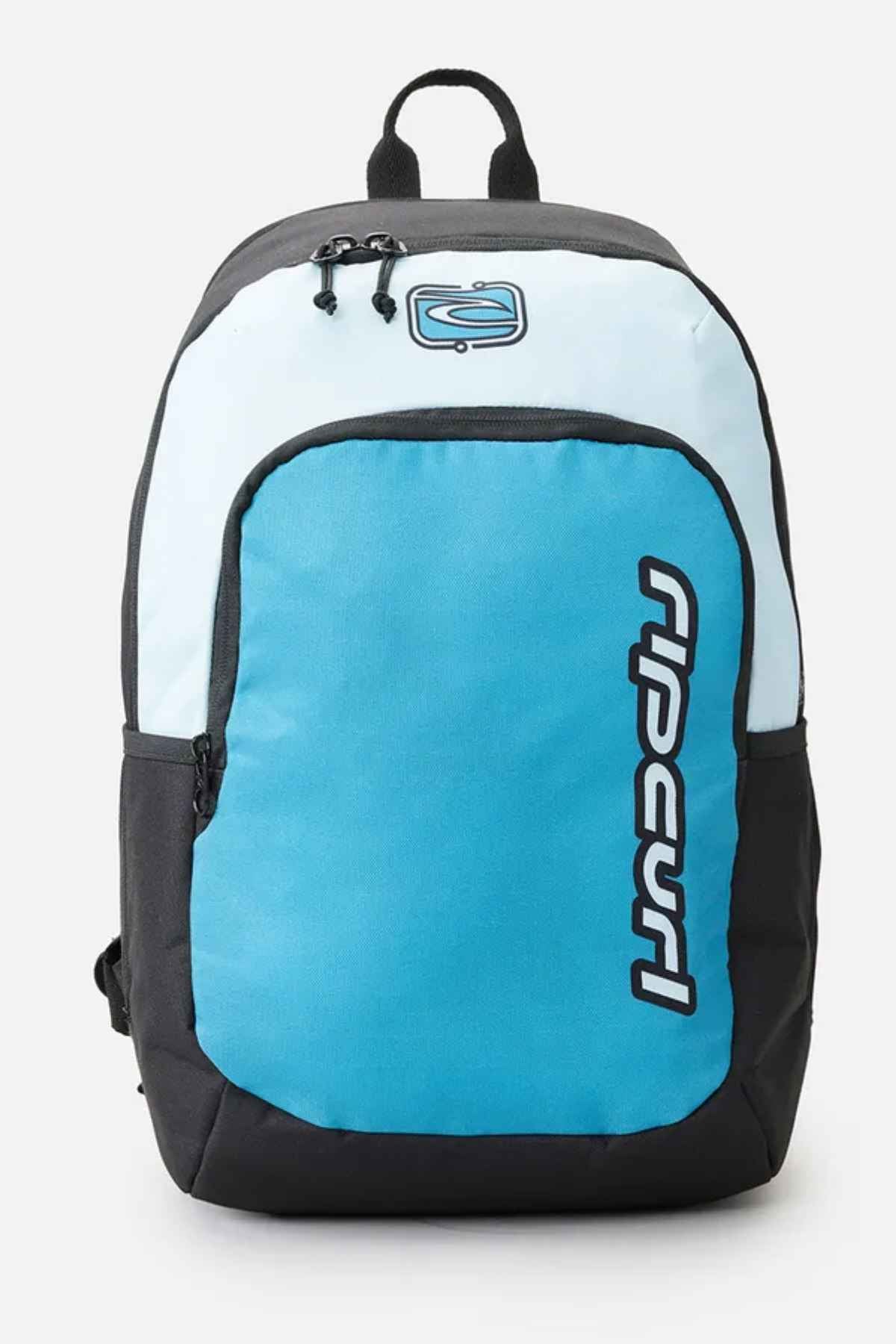Introducing the Rip Curl Ozone 30L Back To School Backpack in blue and black, featuring a front zippered pocket and a logo with stylized text. It is equipped with a top handle and adjustable shoulder straps, offering a simple design perfect for school use.