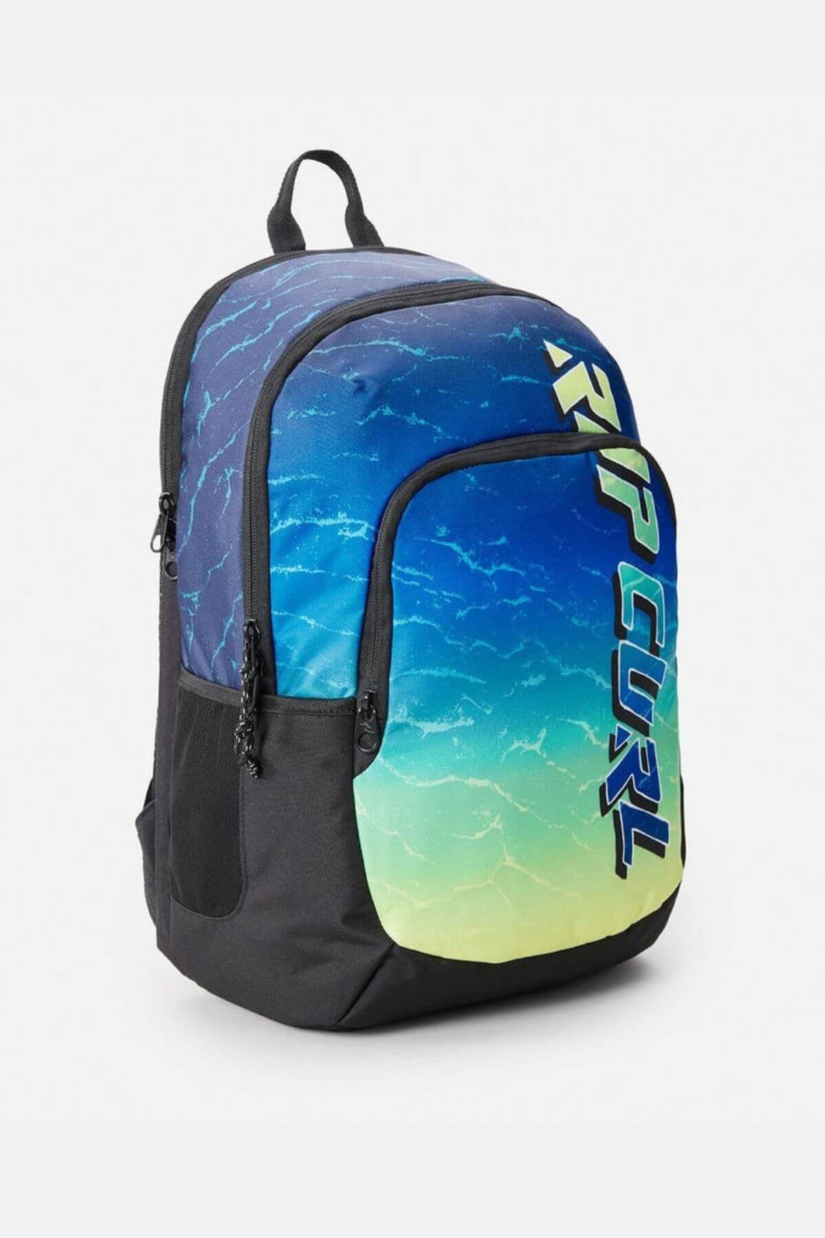 The Rip Curl Ozone 30L Faded Slant Backpack has black sides, a blue-to-yellow water-patterned gradient, bold vertical “RIP CURL” text, multiple zip compartments, organiser pockets, and a dedicated laptop section.