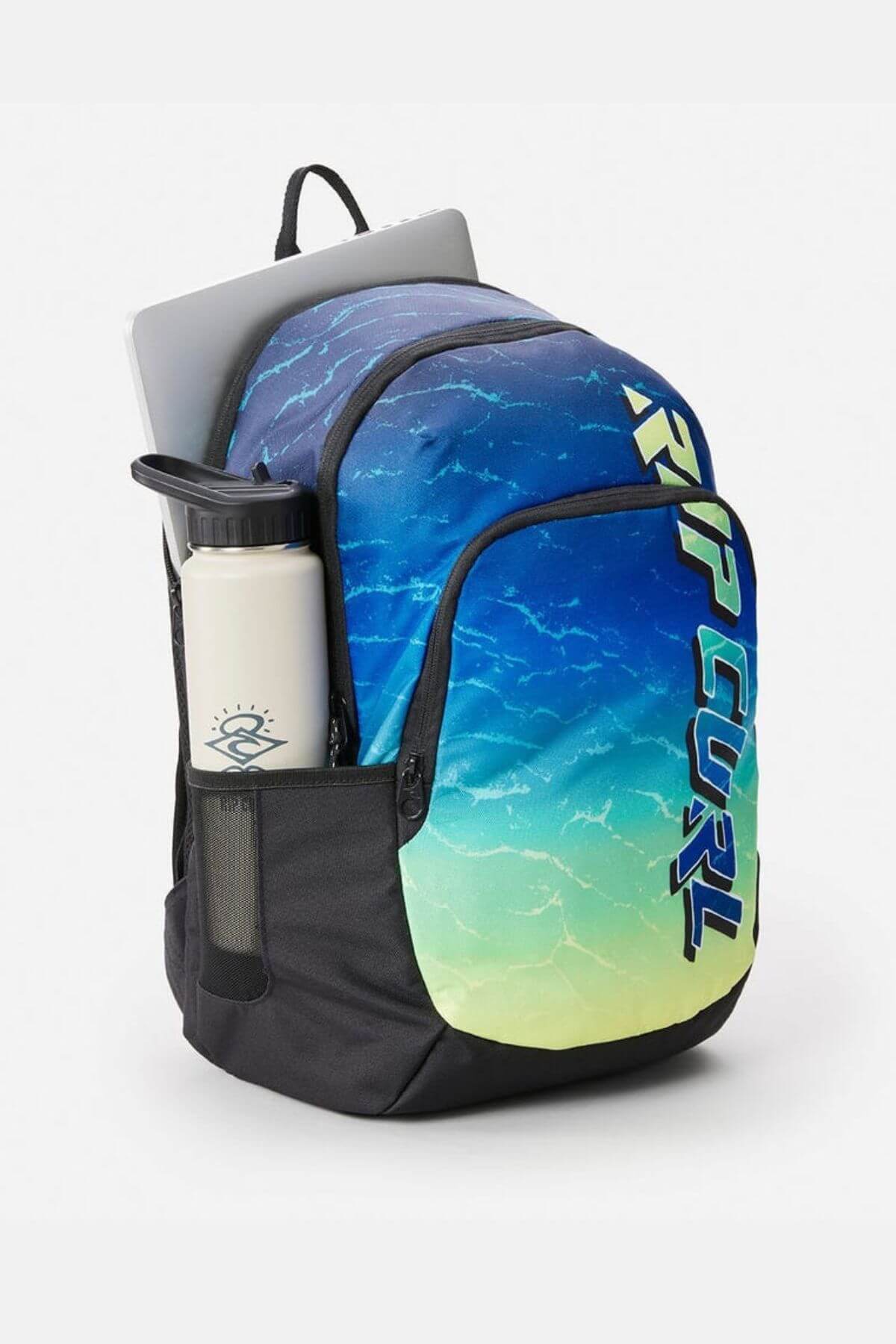 A Rip Curl Ozone 30L Faded Slant Backpack with a blue and green gradient, organiser pockets, a back-laptop section, and "RIP CURL" text is shown with a white Hydro Flask in the side mesh pocket on a plain background.