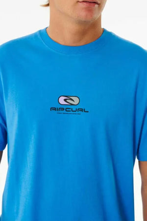 Someone is wearing a Rip Curl Pill Icon Tee, featuring a relaxed fit with a small logo and text on the front. Made from soft cotton, this T-shirt stands out against the plain white background.