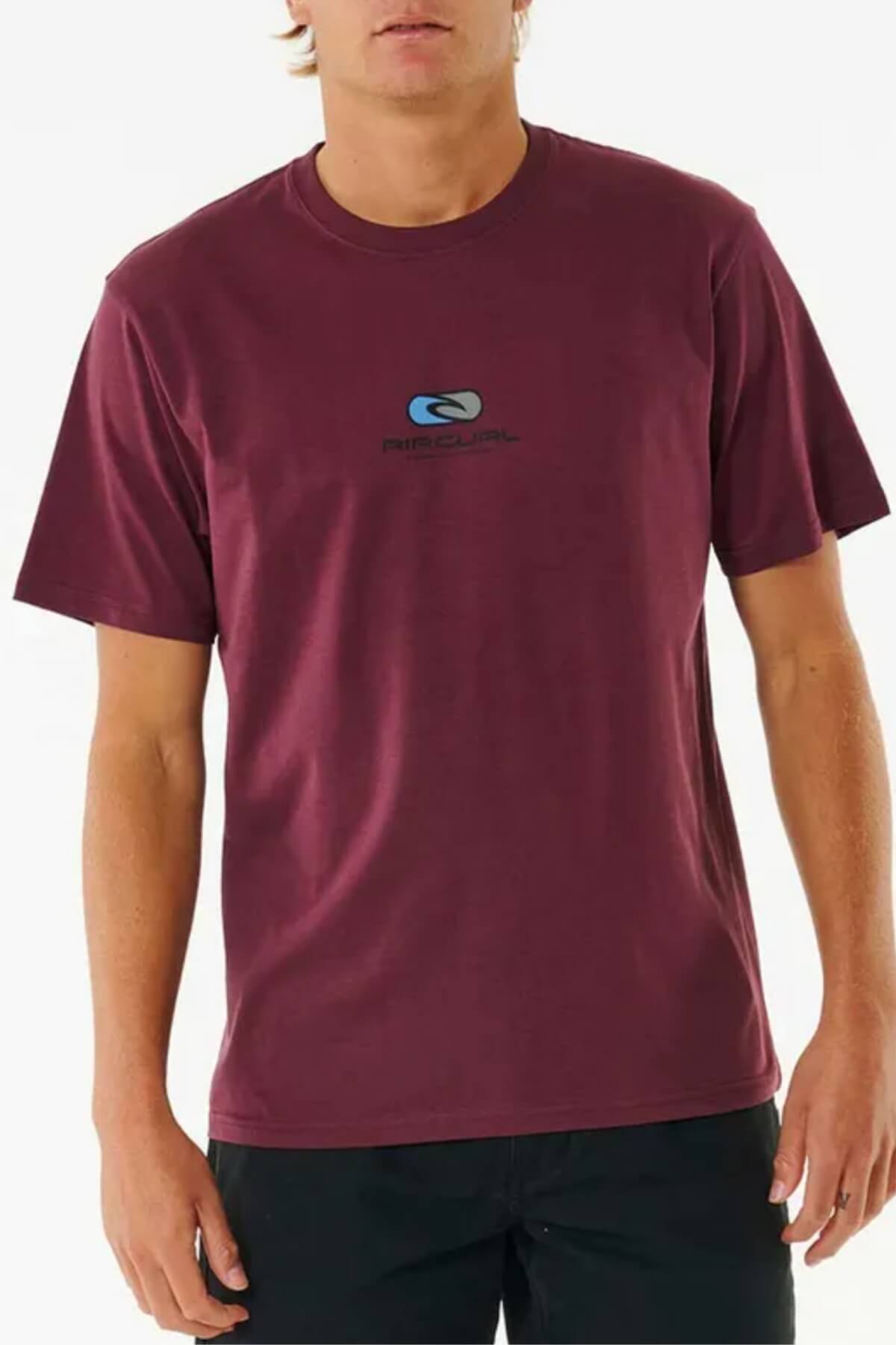 Wearing the Rip Curl Pill Icon Tee, a short-sleeve maroon 100% cotton shirt with a small chest logo, a person stands against a plain white background.