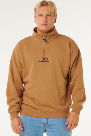 A person faces forward, wearing the Rip Curl Pill Icon 1/4 Zip Crew men's sweatshirt in organic cotton fleece with light blue jeans, set against a plain white background.