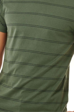 A close-up view showcases a portion of the person's torso wearing the Rip Curl Plain Stripe Tee, featuring its green color with horizontal black stripes. Made entirely from 100% cotton, the fabric looks smooth and includes short sleeves for comfort.