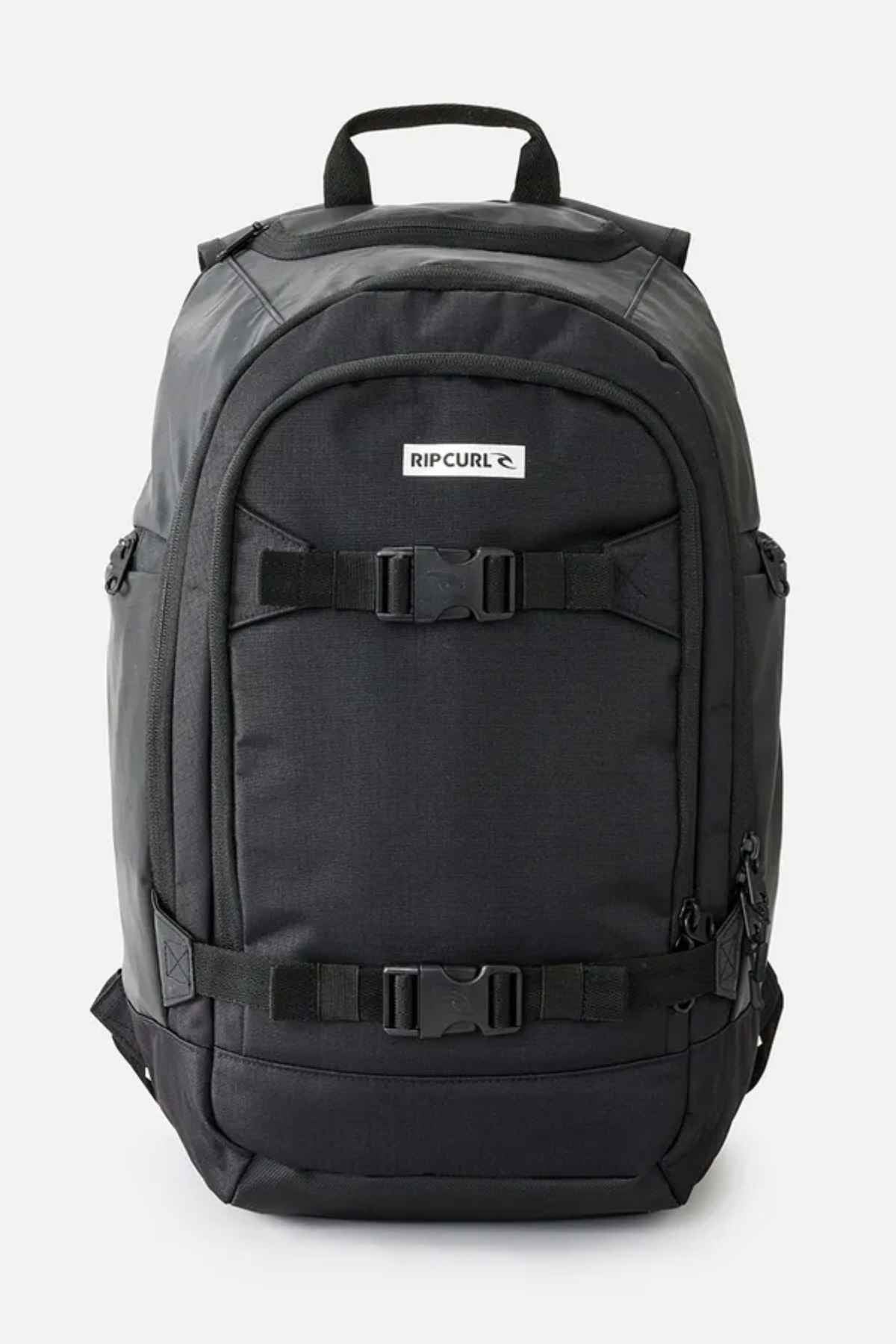 The Rip Curl Posse 33L Icons Backpack, made from recycled polyester, includes multiple compartments and adjustable straps. It features a laptop section and a visible brand logo on the front, along with side pockets and a top handle for convenience.