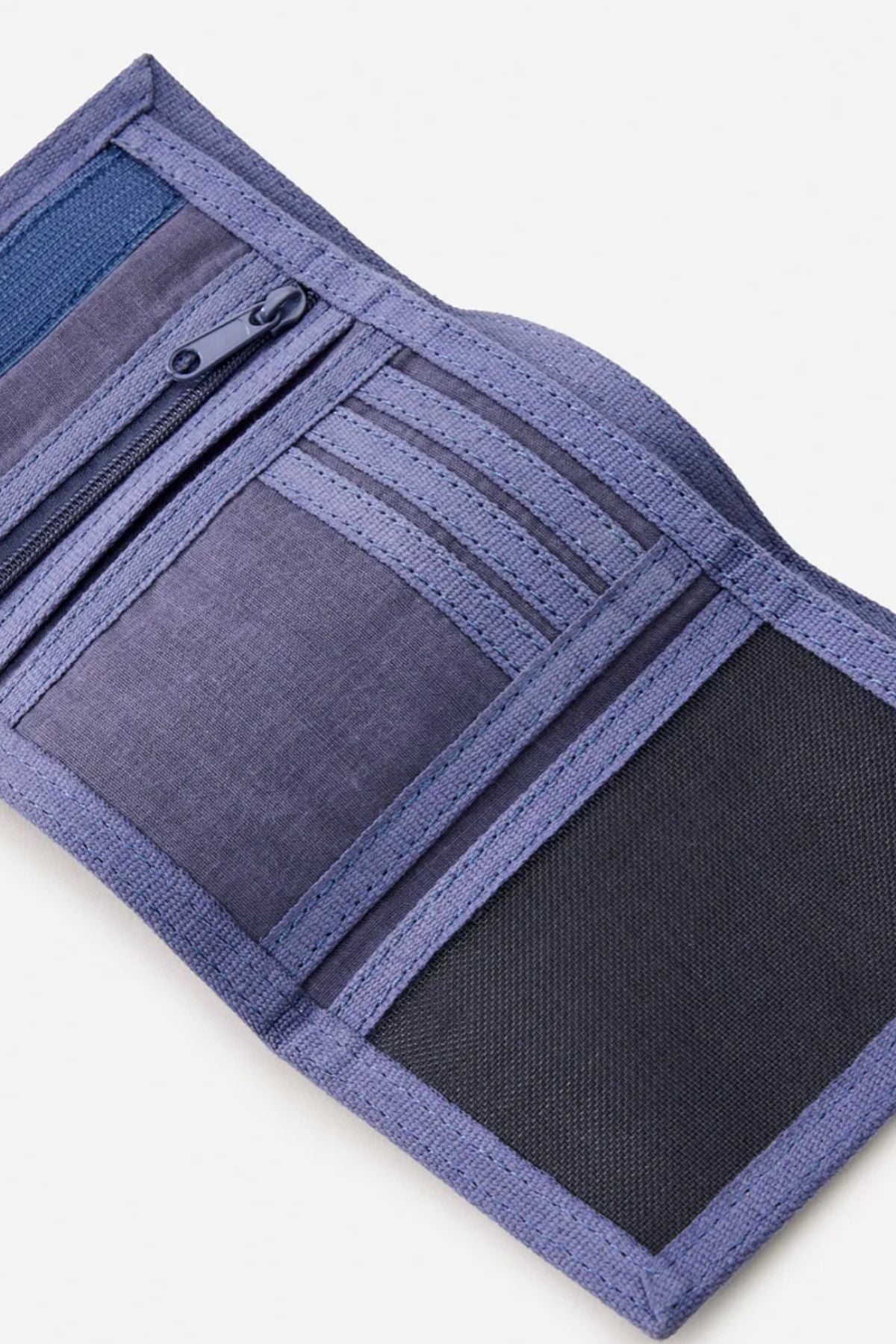 A Rip Curl Revival Cord Surf Wallet in purple lies open on a white background, revealing multiple card slots, a zippered pocket, and a mesh compartment.