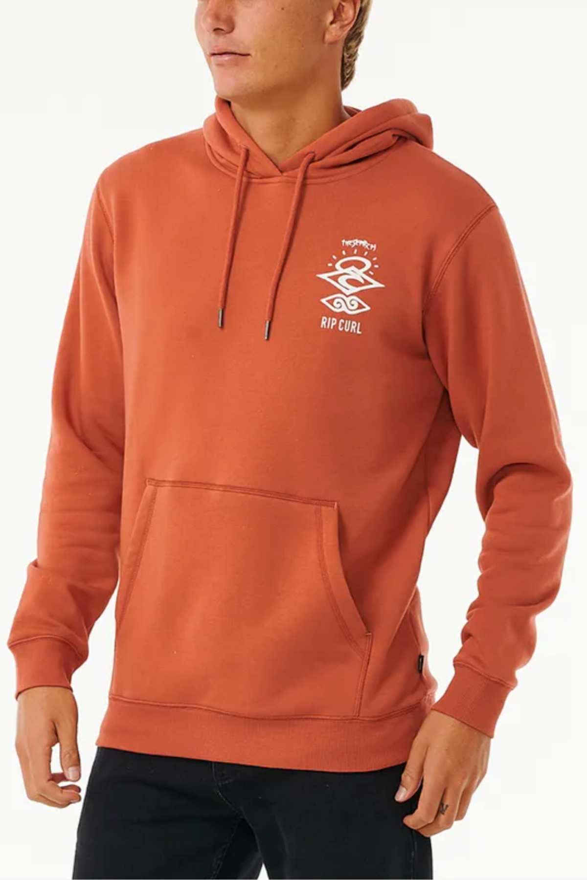 Someone stands against a plain background wearing the rust-colored Rip Curl Search Icon Hood, made from organic cotton with a white graphic and text on the left chest, front pocket, and a drawstring hood.