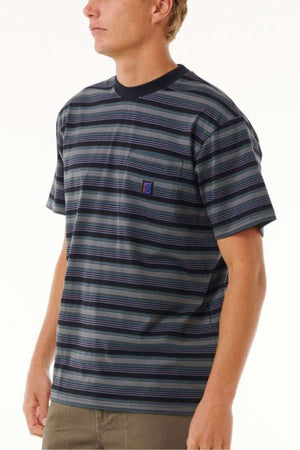 An individual is seen in a Rip Curl Search Stripe Tee, distinguished by its small chest logo. Made from soft cotton, the shirt showcases horizontal stripes in multiple colors while the person stands against a simple backdrop.