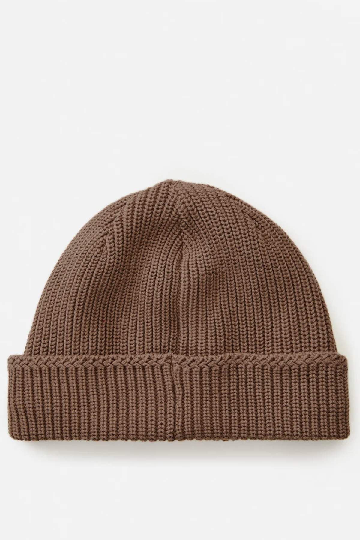 The Rip Curl Searchers Regular Beanie, in brown with a folded brim, stands out on a plain white background. Its ribbed design highlights its texture, while the logo hints subtly at adventure.