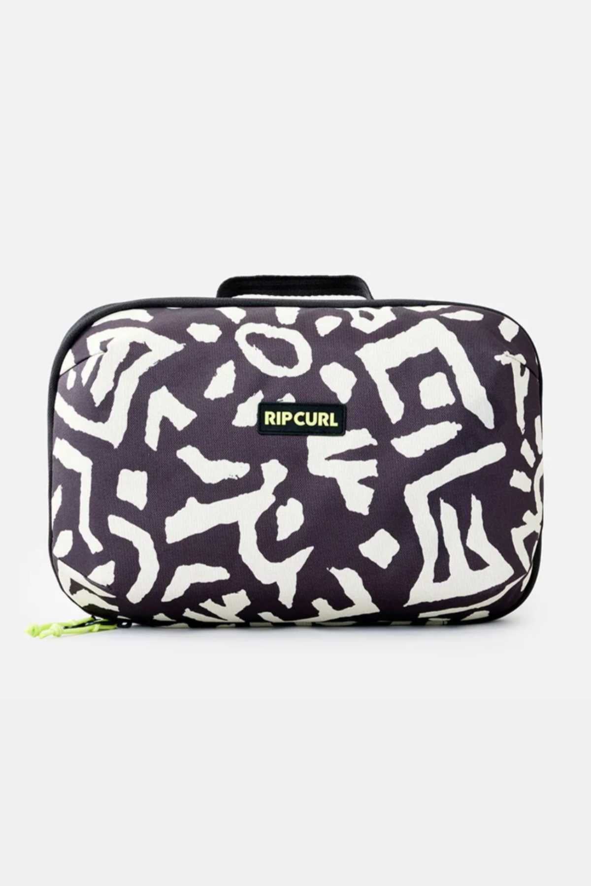 The Rip Curl Ultimate Beauty Case is a rectangular black fabric bag adorned with white geometric patterns and a small "Rip Curl" logo in the center. It features a black handle on top and a small green zipper pull on the bottom left side, making it an ideal travel companion for your beauty essentials. The background is plain white.