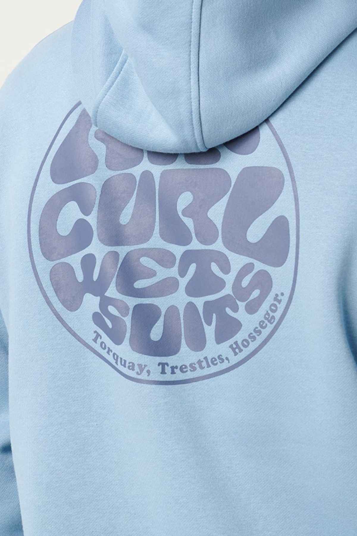 A close-up of the Rip Curl Wetsuit Icon Hood in light blue highlights the bold, wavy “RIP CURL WETSUITS” round Wettie Logo on the back, with “Torquay, Trestles, Hossegor.” written below.