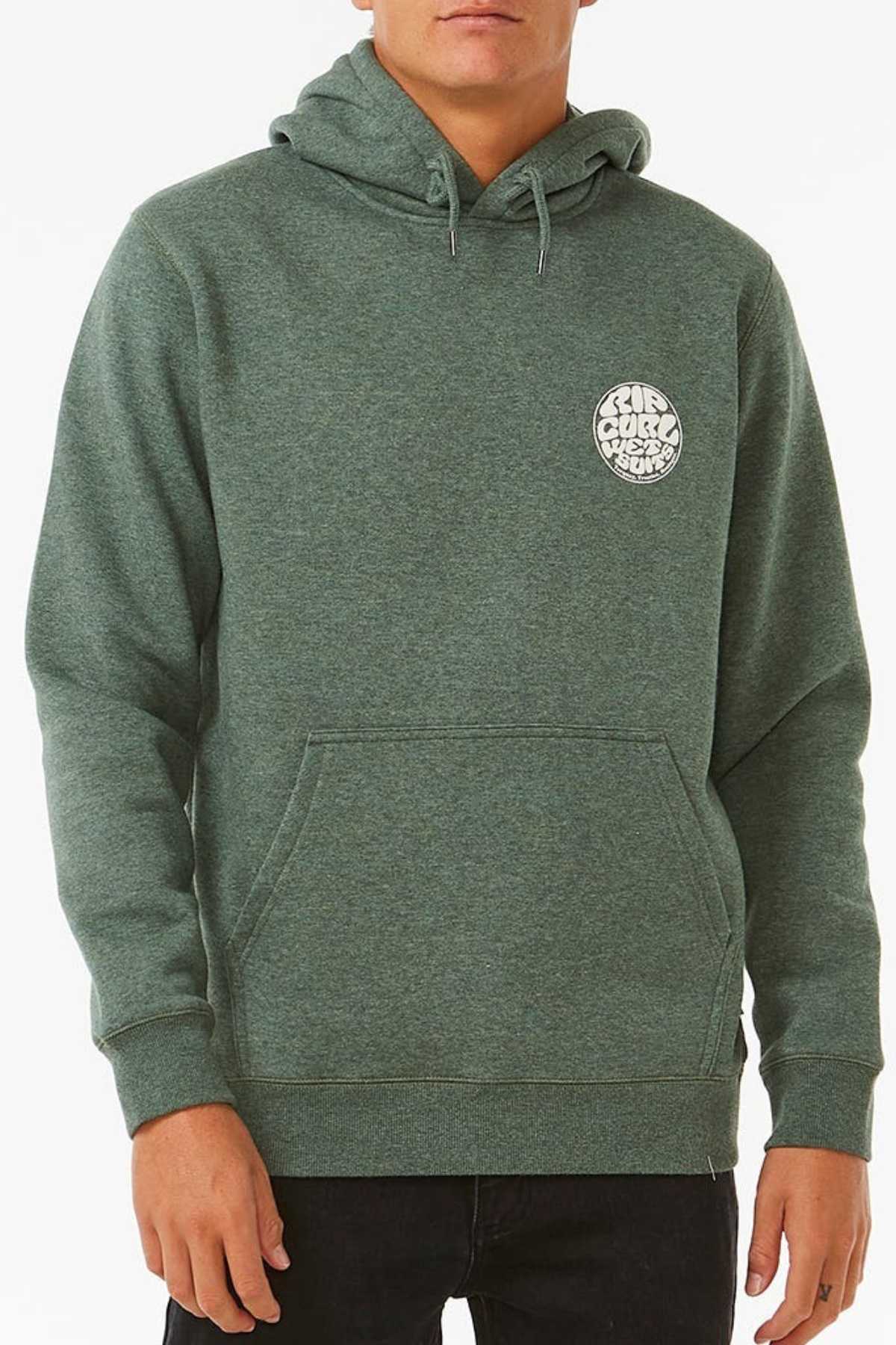 A person wears the green Rip Curl Wetsuit Icon Hood, featuring a circular white logo with abstract text on the chest. Made from Organic Cotton Poly Fleece, it includes a front pocket and drawstrings. They're paired with black pants against a plain white background.