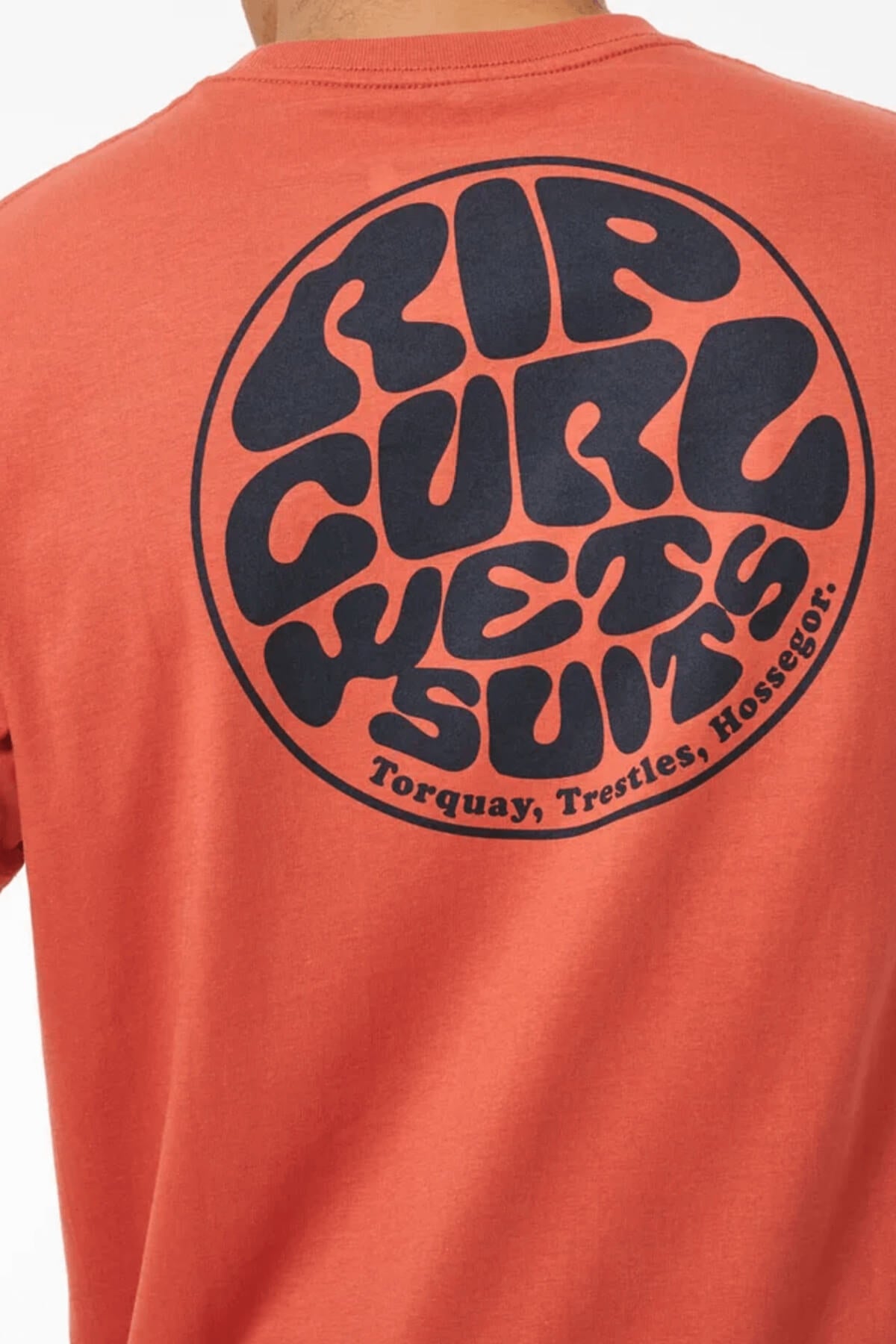 Wearing the Rip Curl Wetsuit Icon Tee—a breathable cotton red shirt with a large circular black "RIP CURL WETSUITS Torquay, Trestles, Hossegor" logo on the back—makes a bold retro statement for any outdoor activity.