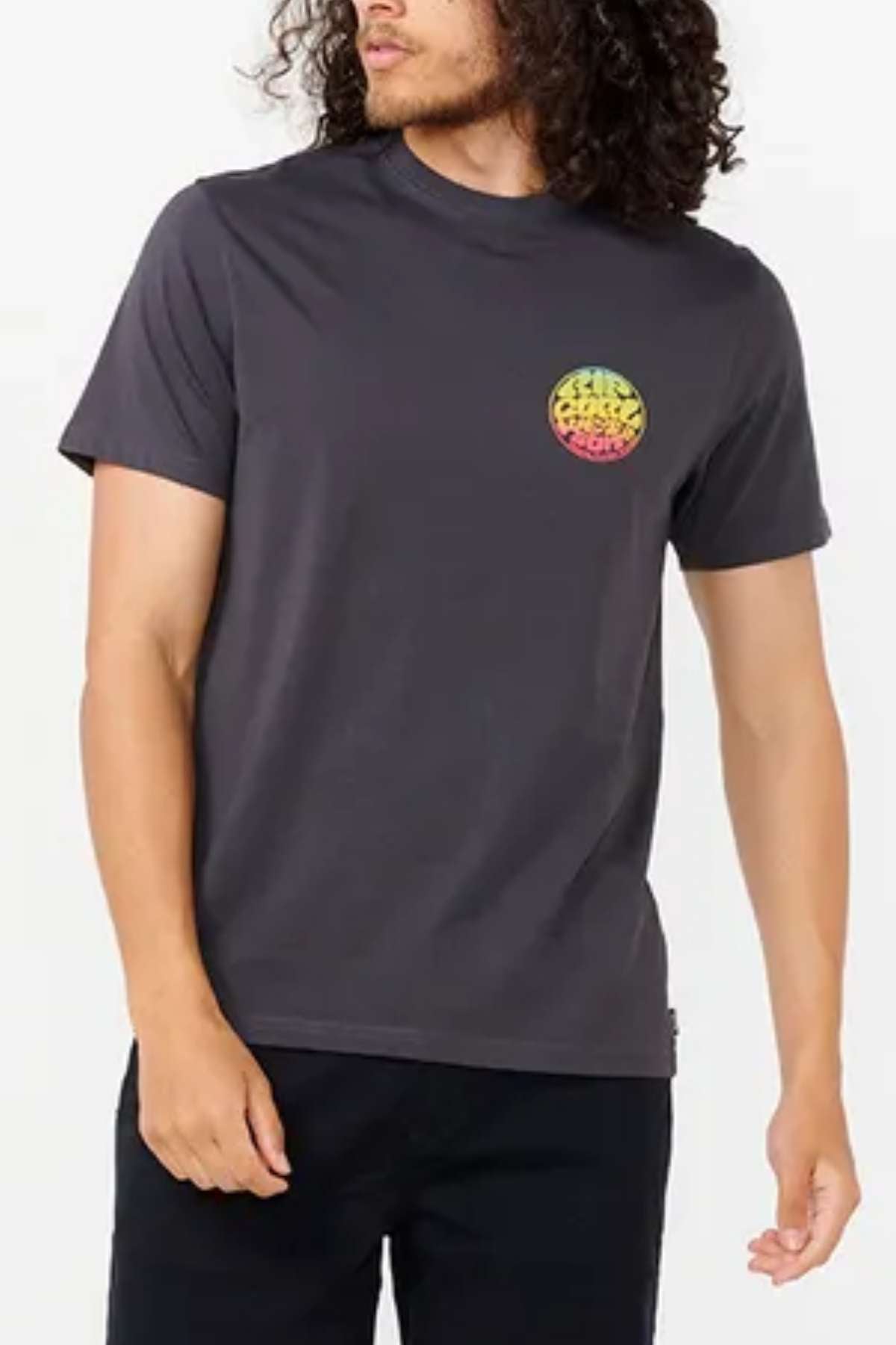 A person with long hair is wearing a dark gray Rip Curl Wetsuit Icon Tee, adorned with a vibrant graphic on the chest. Crafted from lightweight, breathable cotton, this shirt is ideal for outdoor activities. They are standing against a plain background.