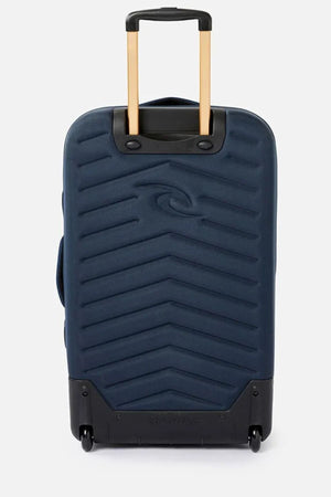 The Rip Curl F-Light Global 100L Sapphire Travel Bag is a stylish blue hard-shell suitcase featuring a textured chevron pattern and two wheels. It comes with a black base, a telescopic handle for easy maneuvering, and is constructed from recycled polyester, ensuring both durability and eco-friendliness.