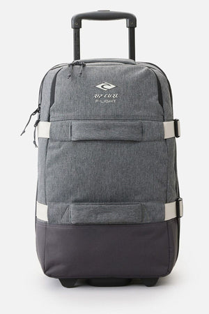 The Rip Curl F-Light Global 100L Classic Surf Travel Bag is a gray rolling suitcase with a telescopic handle and prominently displays the "Rip Curl" logo on the front. It includes two handles, a zippered pocket, and white compression straps for enhanced style and functionality. This bag is crafted from recycled polyester.