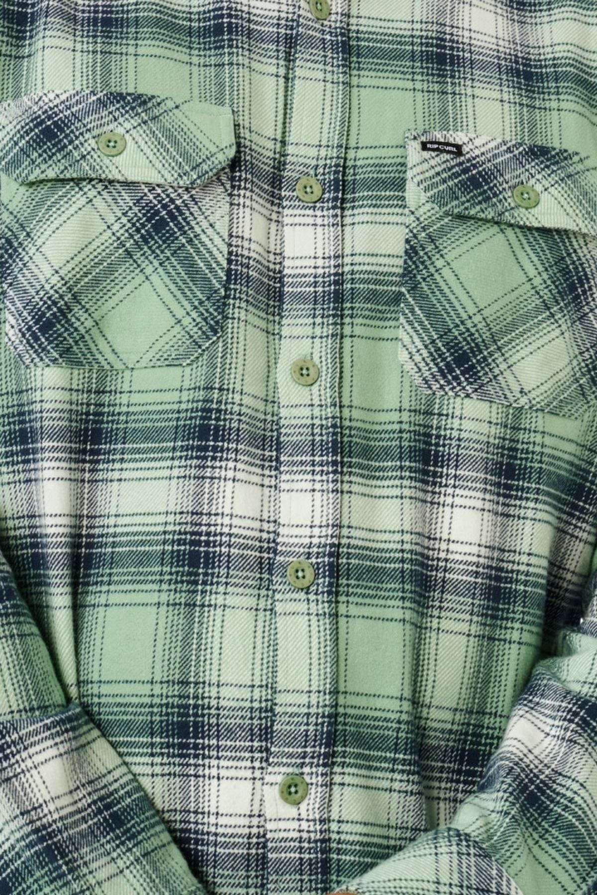 Close-up of the Rip Curl Count Flannel Shirt in green and white plaid with dark navy lines, featuring two chest pockets and green buttons down the front.