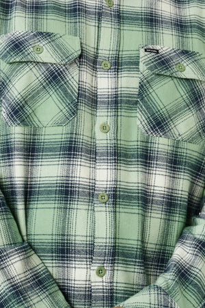 Close-up of the Rip Curl Count Flannel Shirt in green and white plaid with dark navy lines, featuring two chest pockets and green buttons down the front.