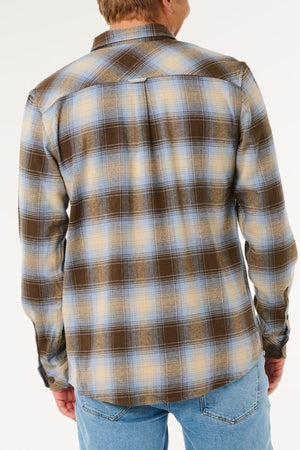 A person seen from behind wears the Rip Curl Count Flannel Shirt in brown, blue, and yellow plaid heavy brushed fabric with light blue jeans, set against a plain white background.
