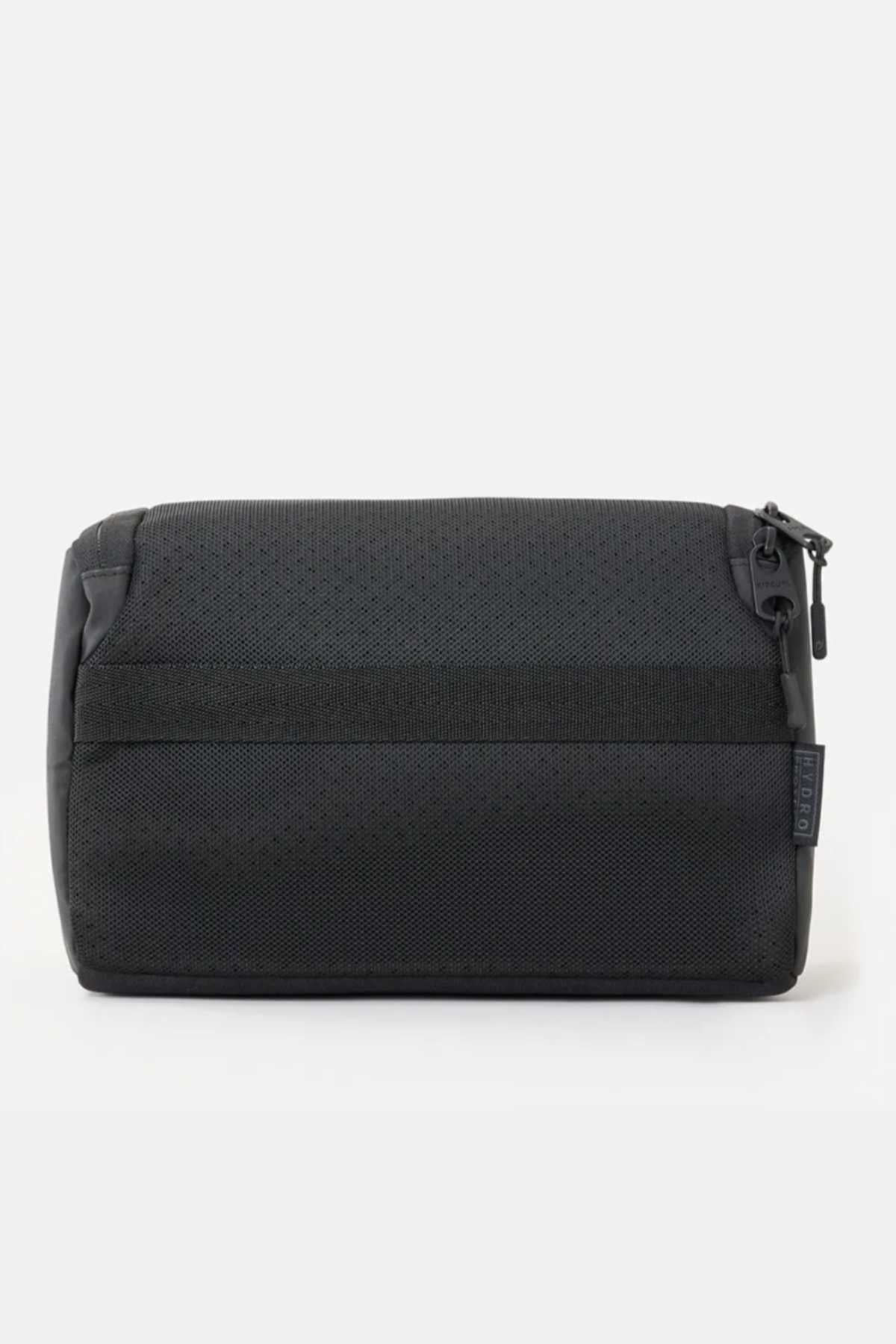 The Rip Curl F-Light Toiletry bag, with a textured fabric and zipper closure, is displayed on a white background. This black bag offers multiple compartments for organization, a ventilated mesh section, and a stylish side tag.