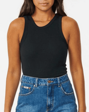 A person wears a black Rip Curl Classic Ribbed Tank and high-waisted blue jeans, standing against a plain white background. The image is cropped from the shoulders to the hips.