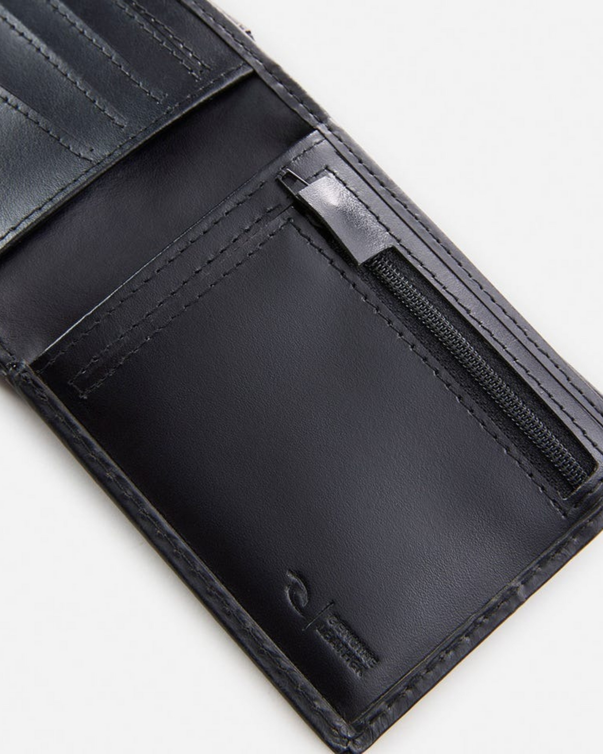 Close-up of the Rip Curl Crossroads RFID 2 In 1 wallet, showcasing multiple card slots and a small zippered pocket, with RFID protection. The rich leather texture is visible, featuring an embossed logo on one corner inside.