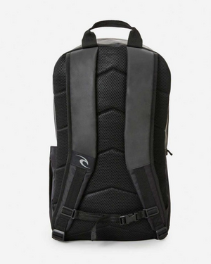 The Rip Curl Overtime 30L Backpack, in black, showcases cushioned shoulder straps and a padded back panel made from recycled polyester. A small logo decorates the lower section, while the sleek, modern design is ideal for carrying essentials comfortably.