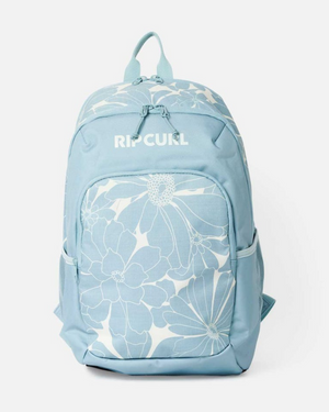 The Rip Curl Ozone 2.0 30L Backpack in light blue features white floral patterns on the front pocket and top, a top handle, side pockets, a laptop section, and multiple zippered compartments.