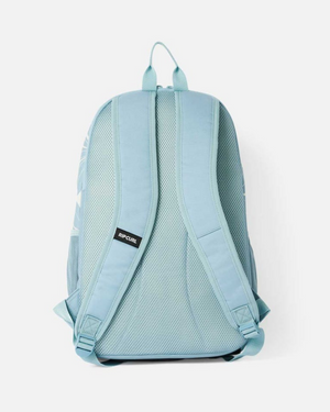 The Rip Curl Ozone 2.0 30L Backpack in light blue is shown from the back on a white background, made of recycled polyester with padded mesh shoulder straps, a laptop section, and a small logo tag on the left strap.
