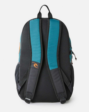 Back view of the Rip Curl Ozone 30L Journeys Backpack in teal and black, made from recycled polyester. It includes padded shoulder straps, mesh padding, a top handle, a small logo on the strap, and extra pockets and zippers on the sides for its spacious 30L capacity.