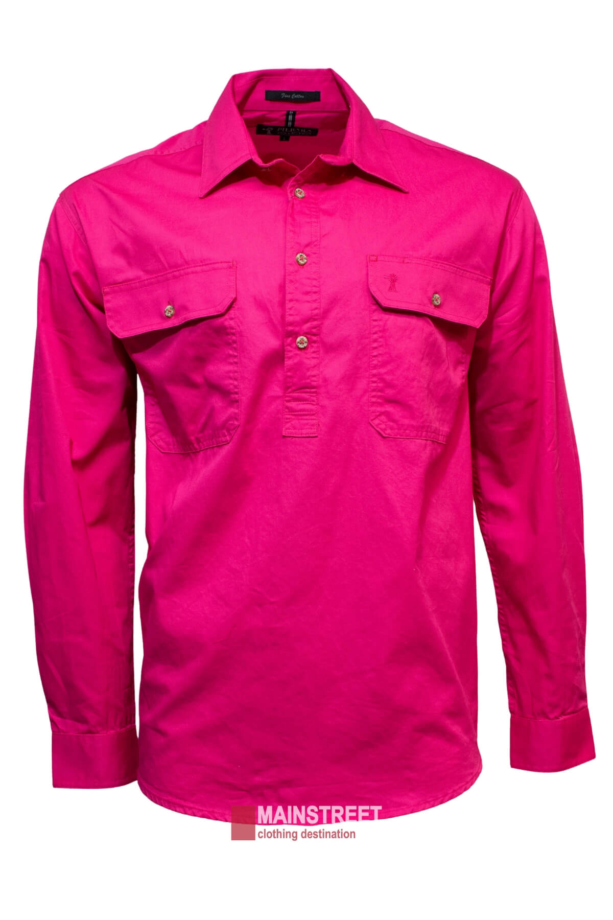The Ritemate Pilbara Long Sleeve Closed Front Shirt is a bright pink men's work shirt featuring long sleeves, a collared neckline, and two buttoned chest pockets. The shirt has a neatly pressed appearance and offers incredible comfort with a UPF 50+ rating. A label below reads "MAINSTREET clothing destination.