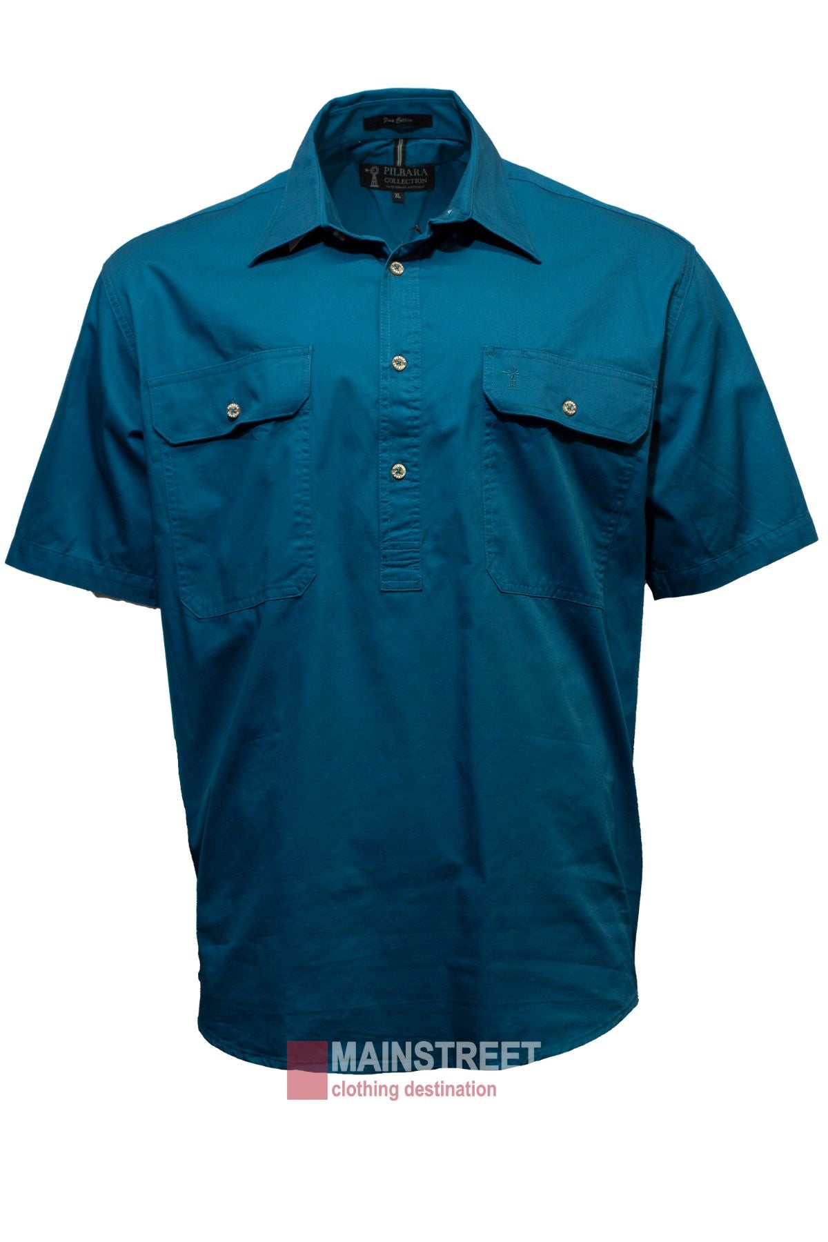 The "Pilbara Short Sleeve Closed Front" men's work shirt is a teal, short-sleeve button-up with two chest pockets, made from 100% cotton. It includes a collar and is shown against a white background with the "Mainstreet clothing destination" watermark at the bottom.