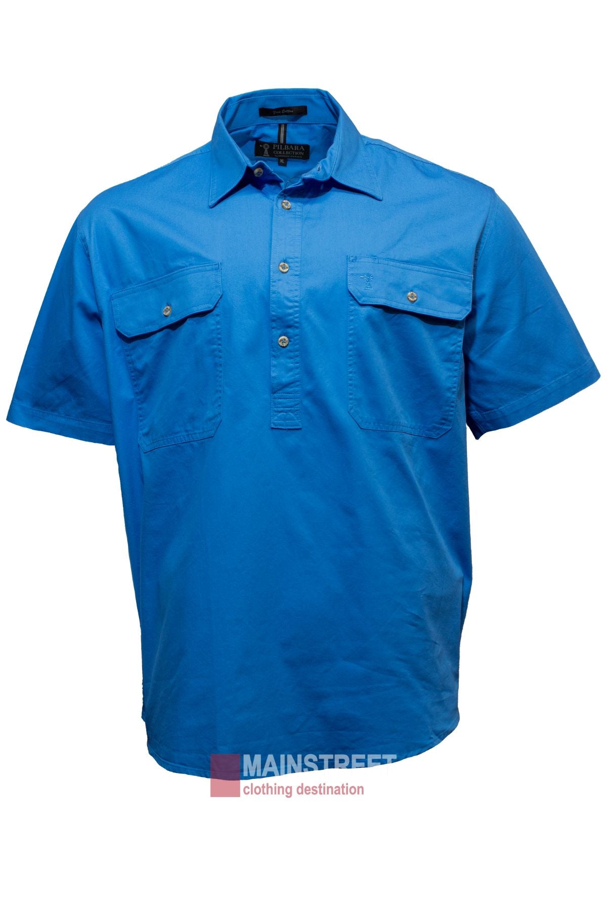 The Pilbara Short Sleeve Closed Front is a bright blue men's work shirt with short sleeves, a button-up collar, two buttoned chest pockets, and made from 100% cotton. The logo "MAINSTREET, clothing destination" appears at the bottom center of the image.