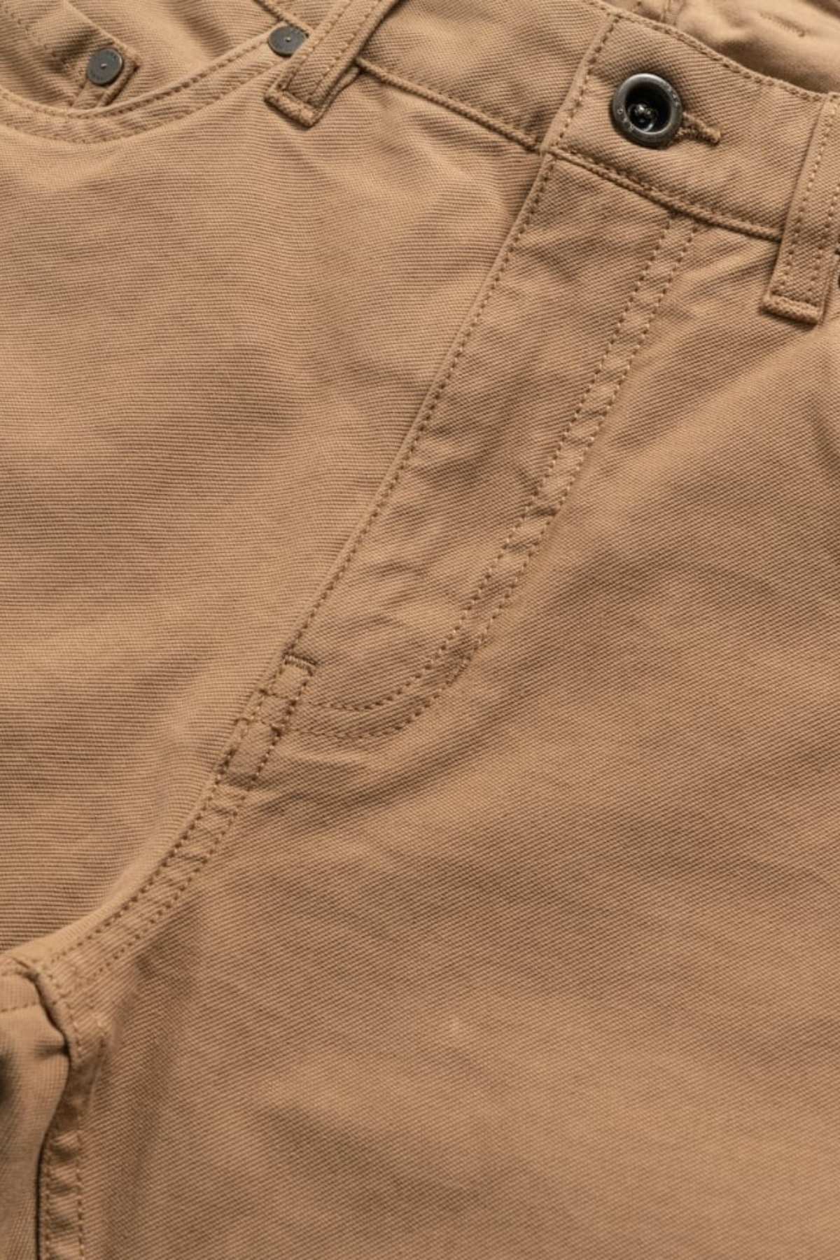 Close-up of the Rodd & Gunn Motion 2 Straight Jean in light brown, featuring a YKK zip fly with visible button, waistband, and pocket stitching. The smooth comfort stretch motion fabric is slightly textured for style and ease of movement.