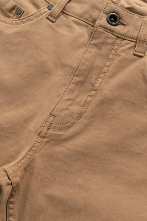 Close-up of the Rodd & Gunn Motion 2 Straight Jean in light brown, featuring a YKK zip fly with visible button, waistband, and pocket stitching. The smooth comfort stretch motion fabric is slightly textured for style and ease of movement.