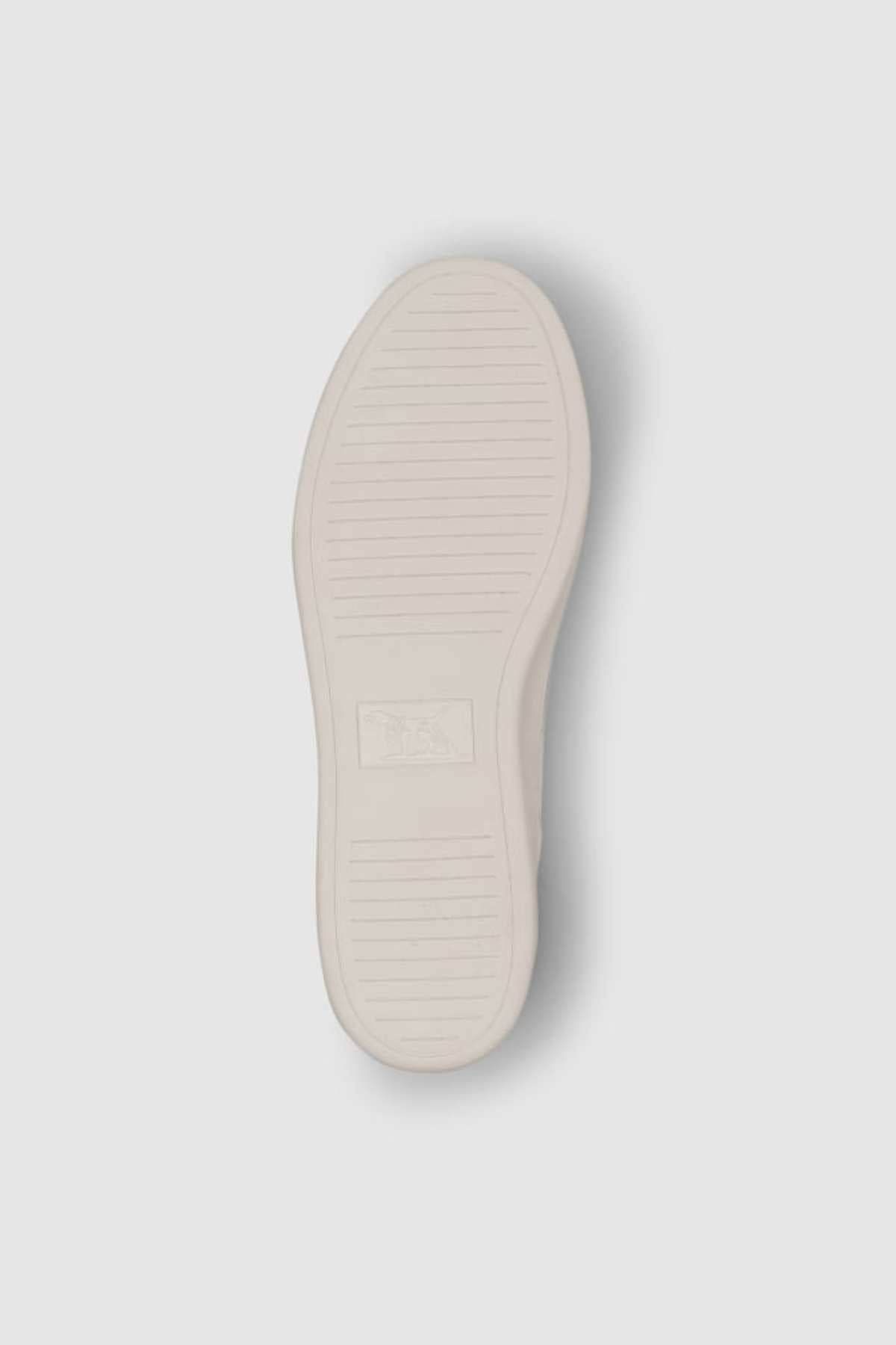 The image shows the underside of a Rodd & Gunn Sussex Street Sneaker, featuring a white rubber sole with horizontal grooves and a central rectangular logo, emphasizing its durable outsole.