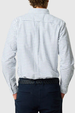 A person with curly hair, seen from behind, wears the Rodd & Gunn Gunn Check Oxford 3 Sports Fit Shirt in long sleeves and dark pants with a black belt, hands in pockets.
