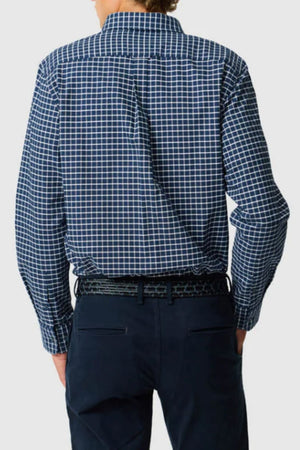 Seen from behind, a person wears the Rodd & Gunn Gunn Check Oxford 3 Sports Fit Shirt in blue and white checks, tucked into dark trousers with a black belt, against a plain light background.