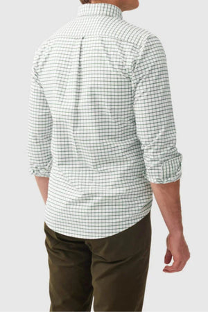 A man is seen from behind wearing the Rodd & Gunn Gunn Check Oxford 3 Sports Fit Shirt in green check, paired with olive green pants. His sleeves are rolled up as he stands against a plain light gray background.