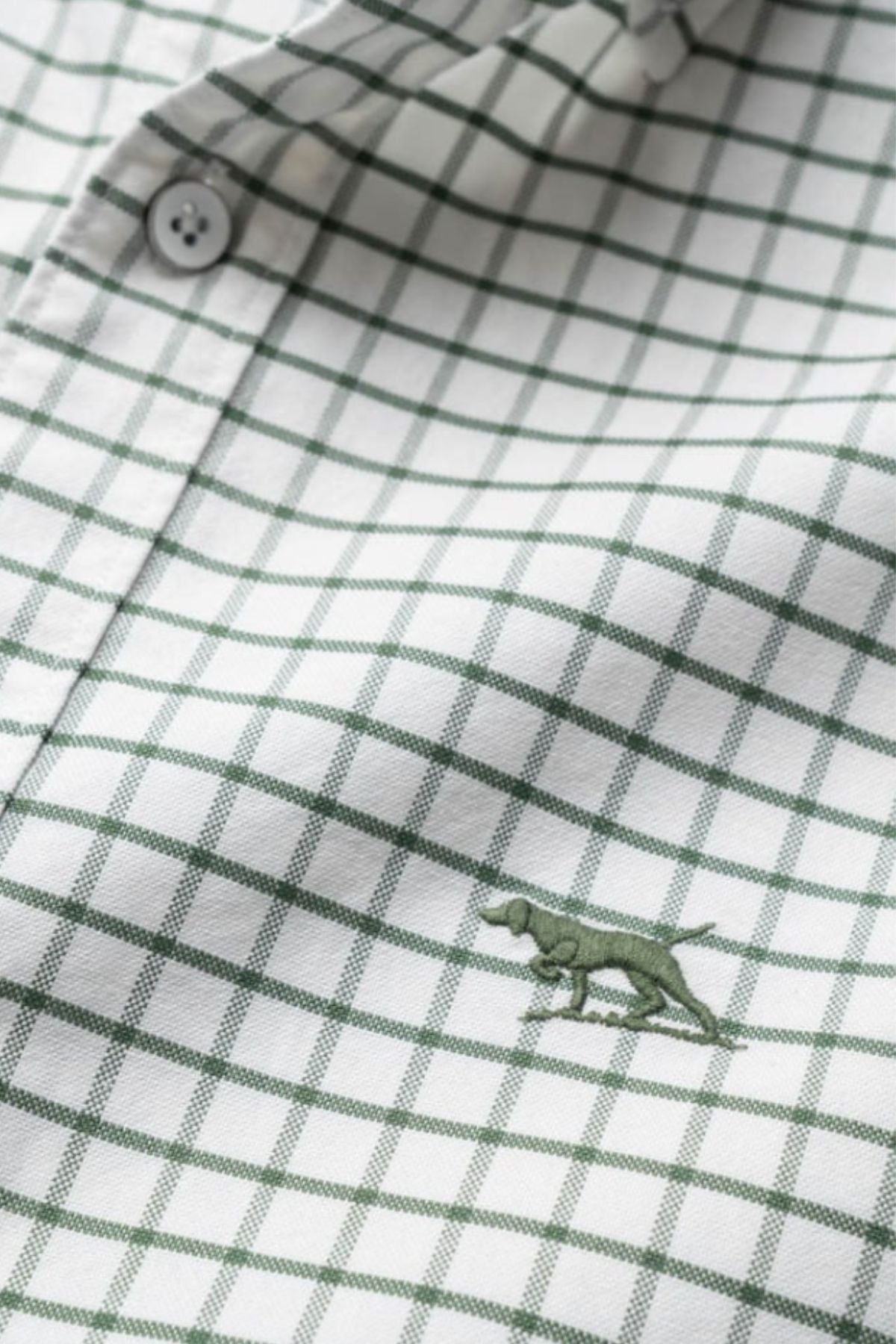A close-up of the Rodd & Gunn Gunn Check Oxford 3 Sports Fit Shirt, made from Australian cotton with a green check pattern and a small green dog embroidery near the bottom center.