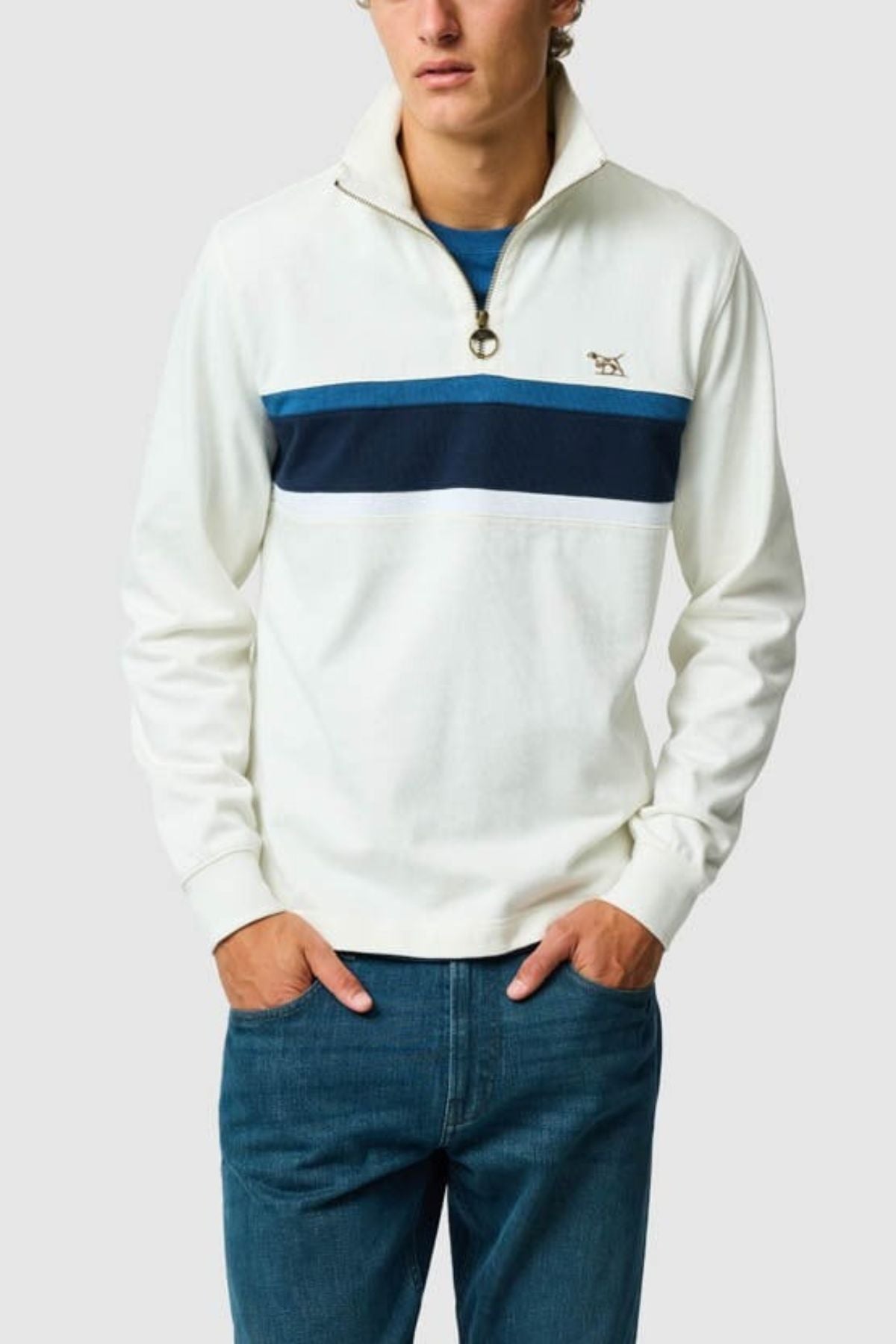 A person models the Rodd & Gunn Chesterfield Sweat, a sustainable sweatshirt with blue chest stripes, paired with blue jeans and hands in pockets against a plain backdrop for an effortless eco-conscious look.