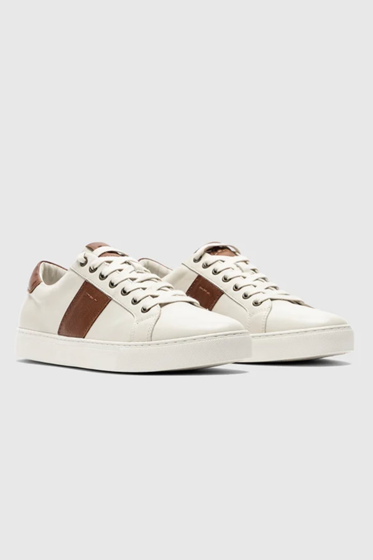 The Rodd & Gunn Endeavour Cruise Sneaker features brown side and heel accents, white laces, and a white sole, displayed on a light gray background.