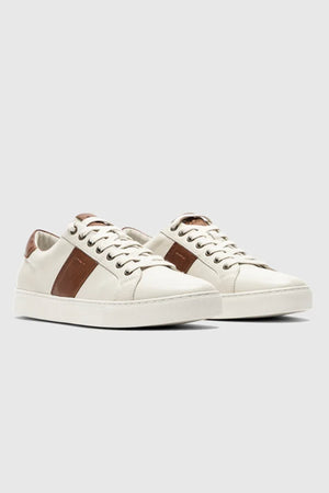 The Rodd & Gunn Endeavour Cruise Sneaker features brown side and heel accents, white laces, and a white sole, displayed on a light gray background.
